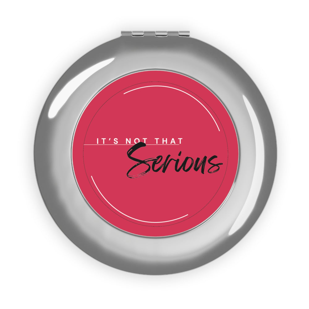 Compact mirror with pink center and 'It's Not That Serious' text on a white background