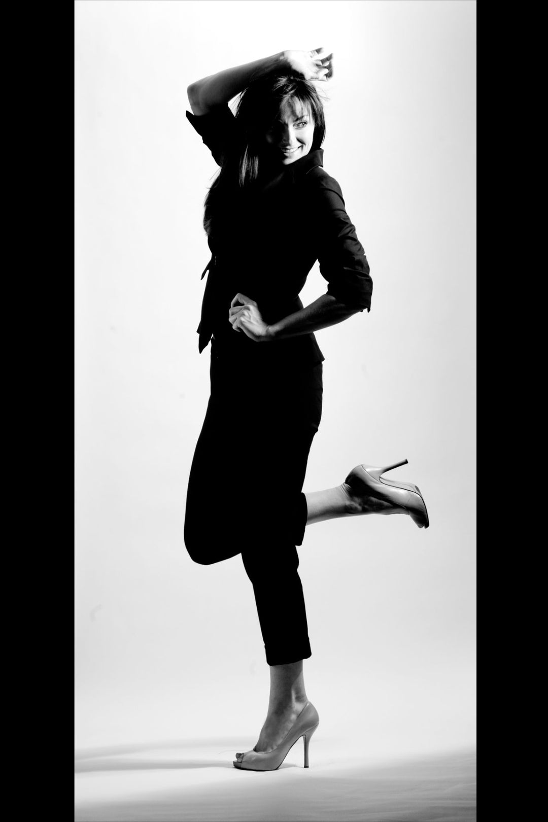 A photo of a young women in a standing model pose with one foot raised