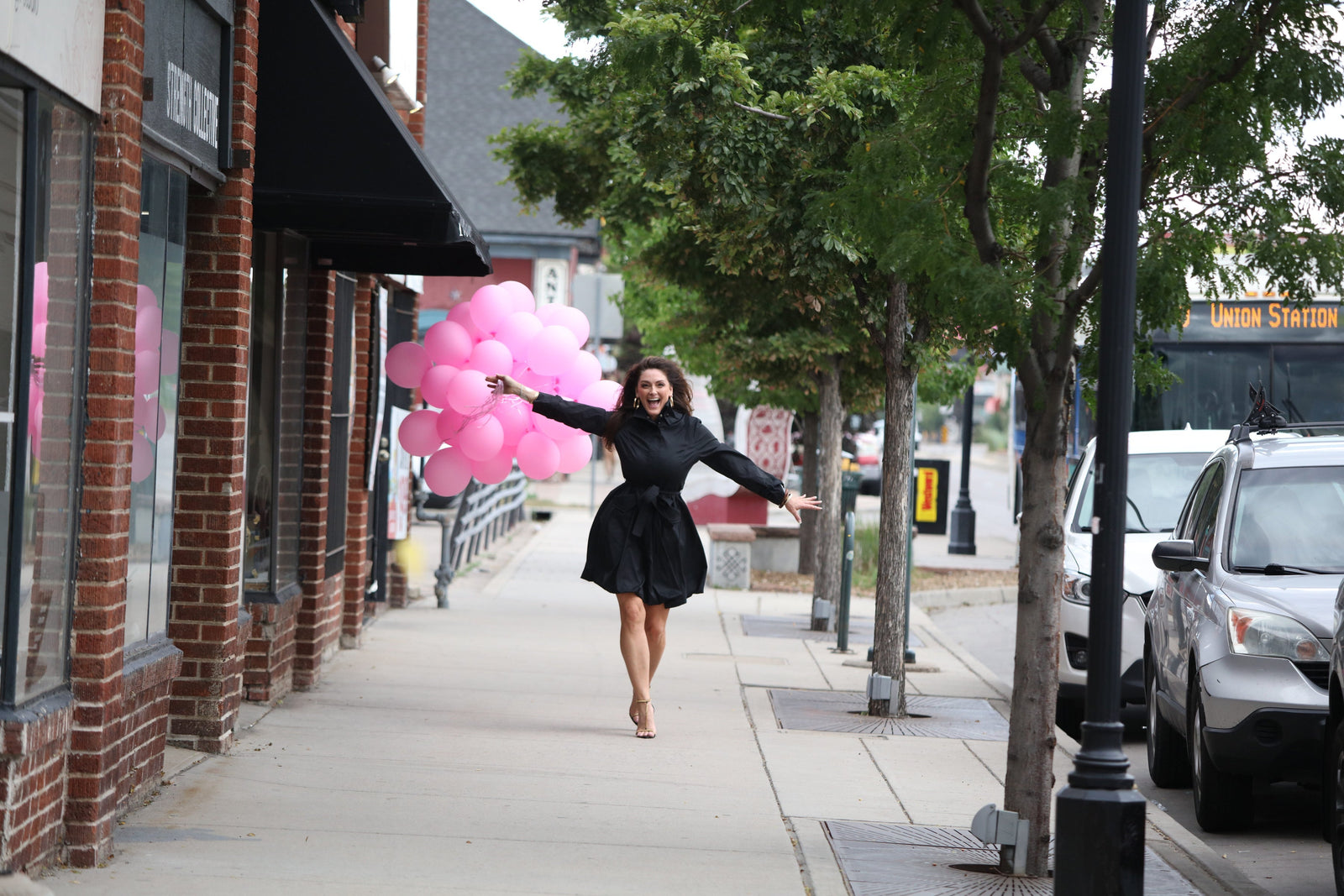 Carrie Hunter Strutting Down the Street with Pink Balloons