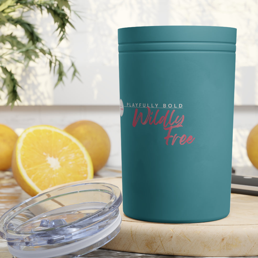 Teal tumbler with 'Playfully Bold, Wildly Free' text on a wooden surface with lemons in the background