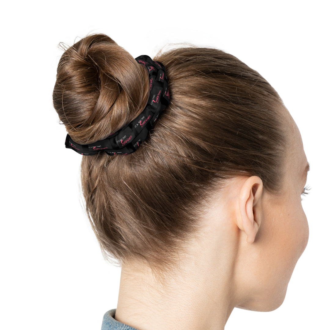 A black scrunchie with pink text all-over print, on a white background.