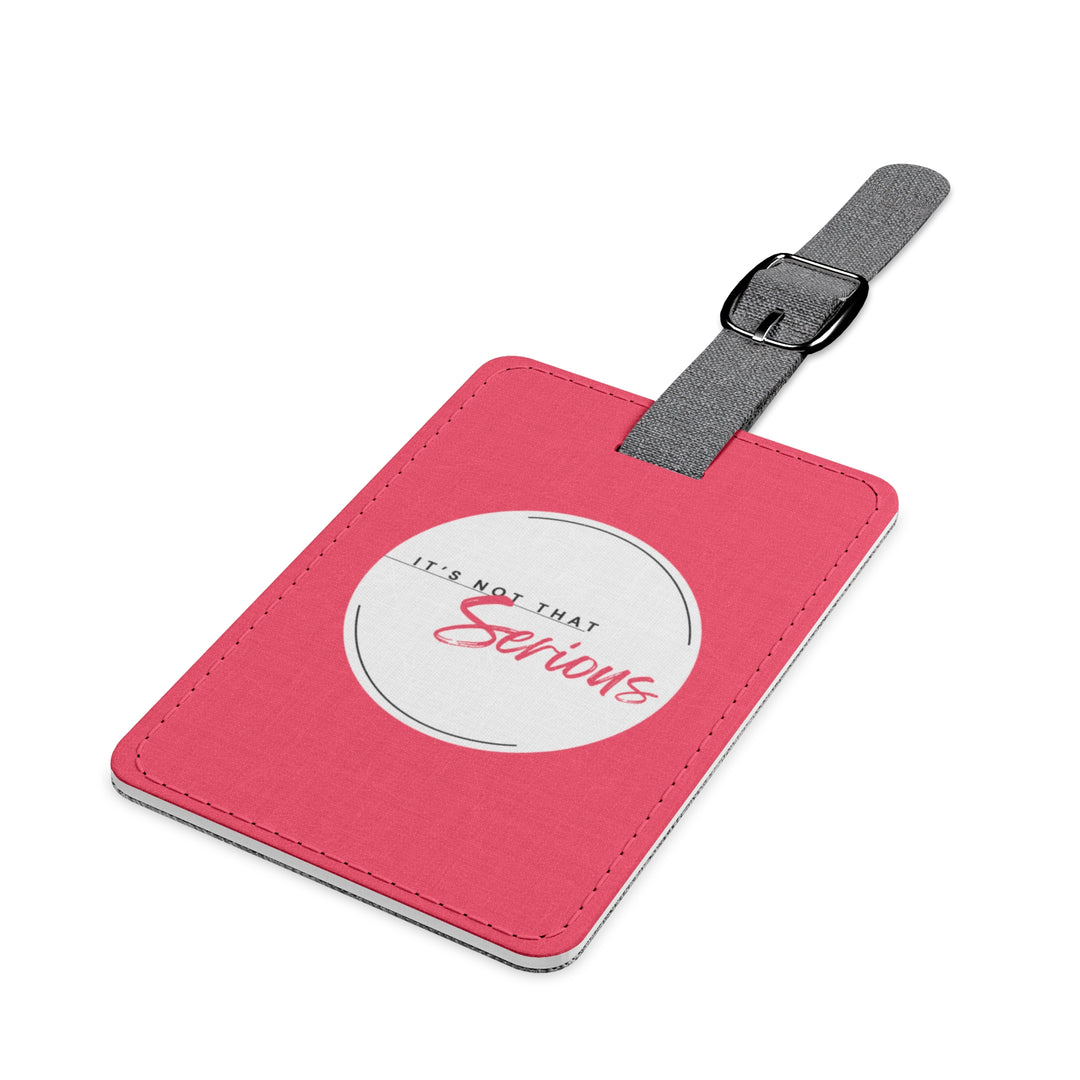 Pink luggage tag with a white label and gray strap on a white background