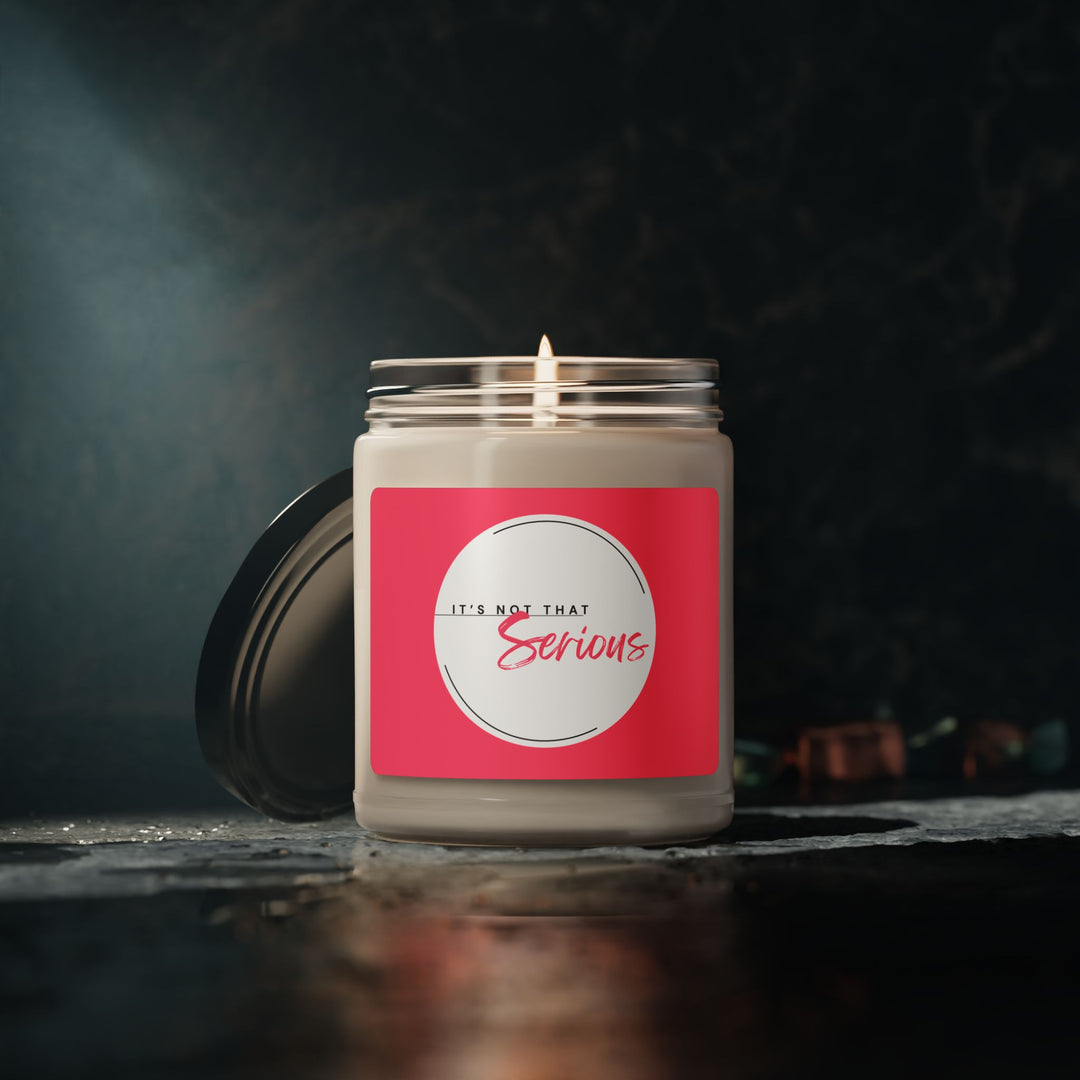 Candle in a glass jar with a pink label on a dark background