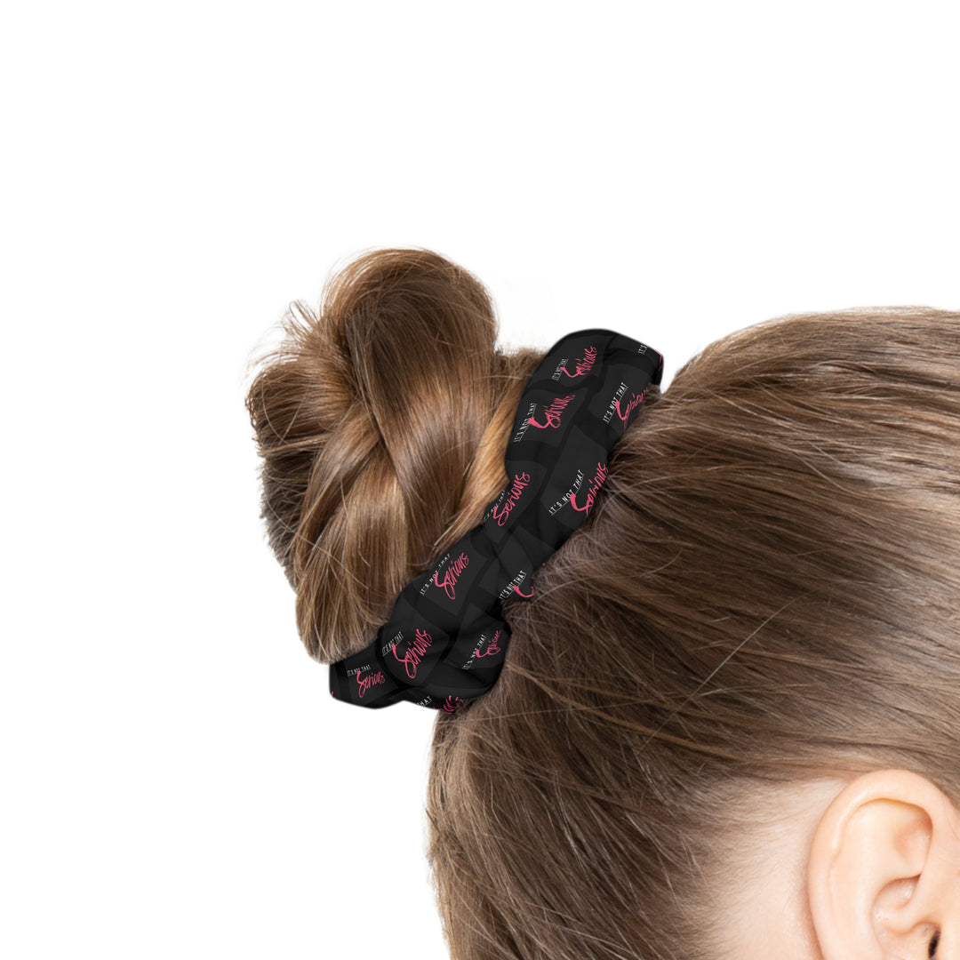 A black scrunchie with pink text all-over print, on a white background.