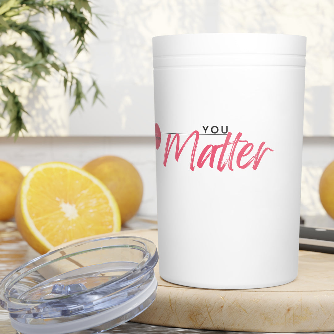 White tumbler with 'YOU Matter' text on a table with lemons and a plant in the background