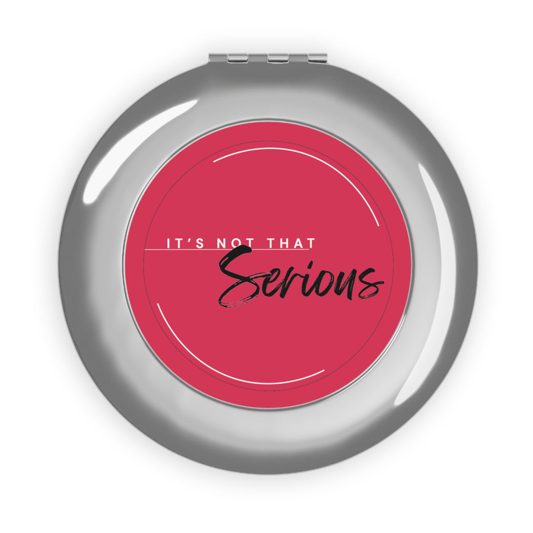 Compact mirror with pink center and 'It's Not That Serious' text on a white background