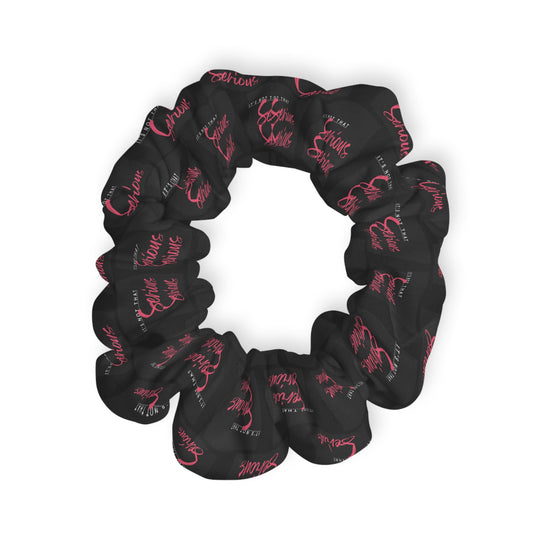 A black scrunchie with pink text all-over print, on a white background.