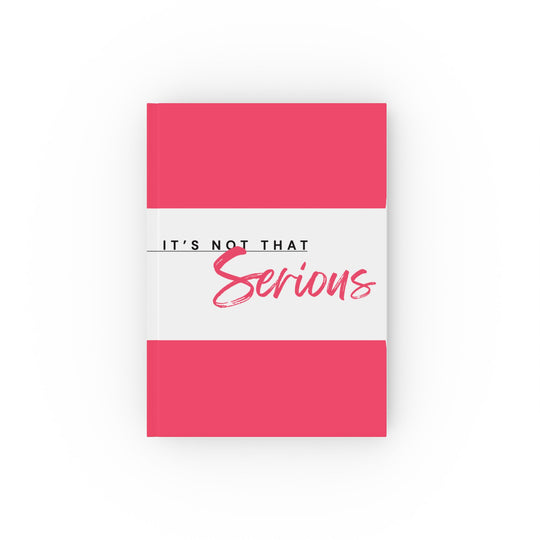 A hard backed journal with vibrant pink and white print on the cover, titled 'It's Not That Serious',