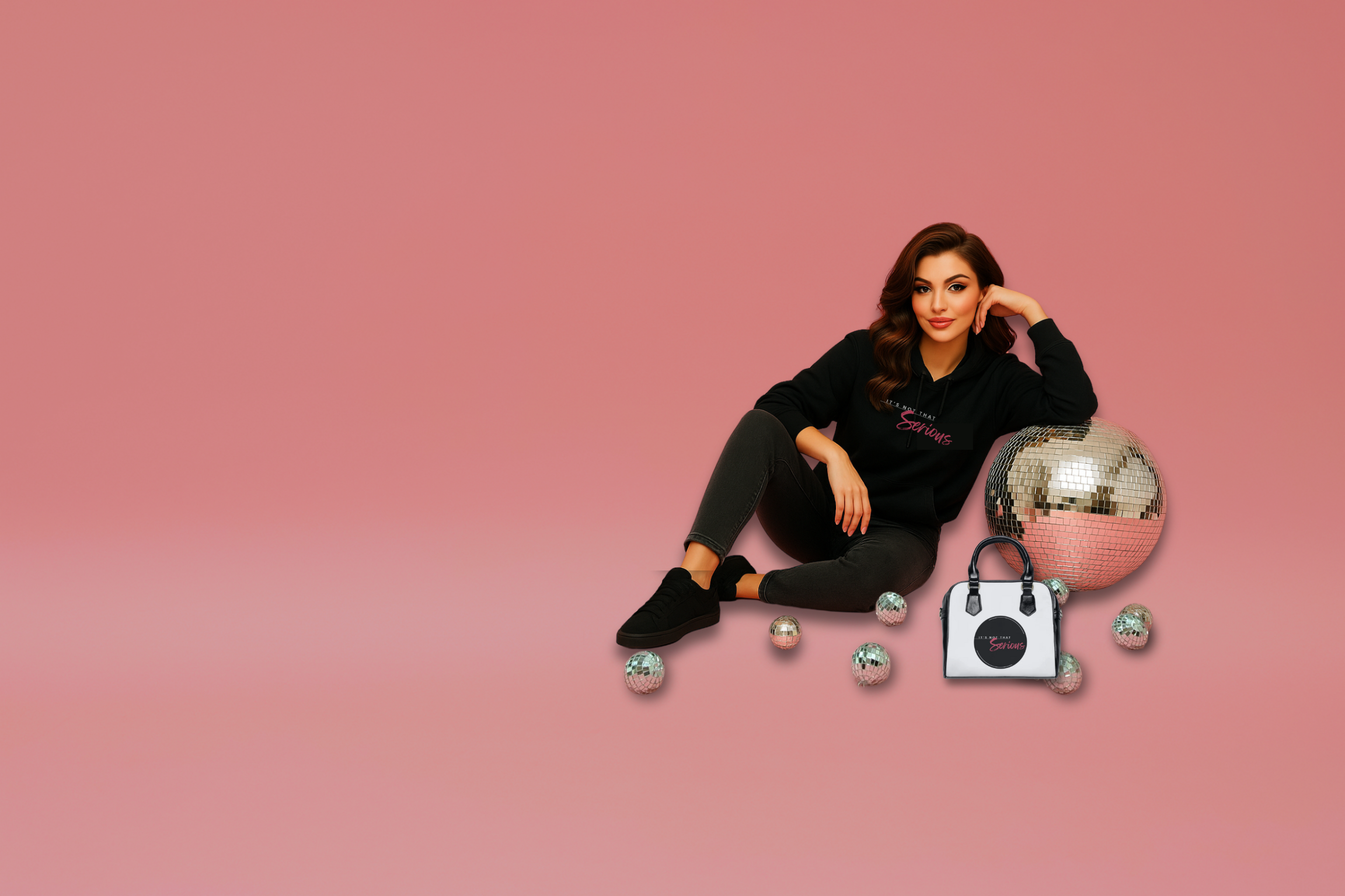 A woman sitting with a It's Not That Serious handbag and wearing a hoodie with the logo leaning on a disco ball